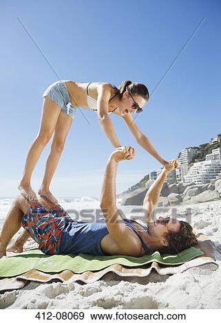 Stock Photo - Playful couple on beach. Fotosearch