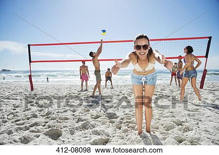 Portrait of confident woman gesturing thumbs up on beach volleyball court View Large Photo Image Stock Photo - Portrait of confident woman gesturing thumbs up on beach volleyball court. Fotosearch