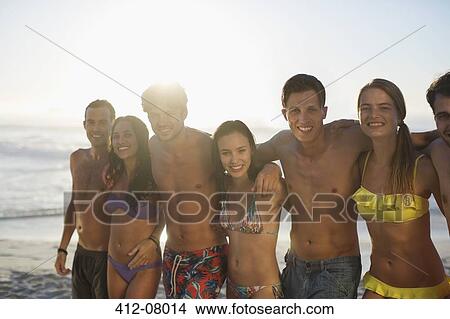Picture - Portrait of friends in bikinis and swim trunks on beach. Fotosearch