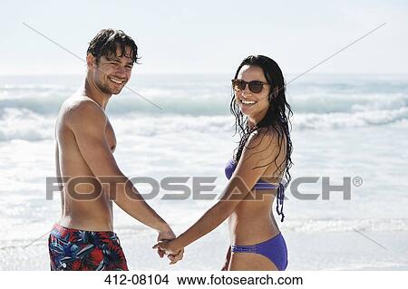 Portrait of happy couple holding hands on beach View Large Photo Image Picture - Portrait of happy couple holding hands on beach. Fotosearch