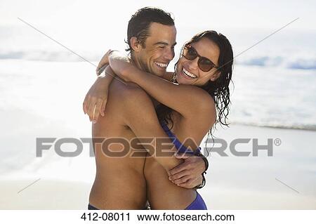 Portrait of happy couple hugging on beach View Large Photo Image Stock Image - Portrait of happy couple hugging on beach. Fotosearch