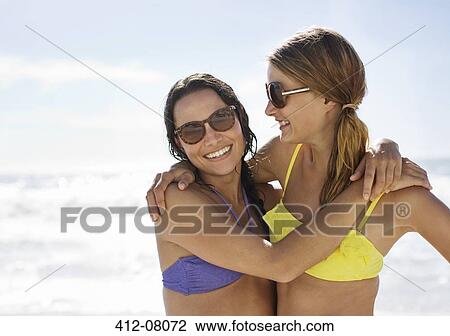 Portrait of happy friends in bikinis hugging on beach View Large Photo Image Stock Image - Portrait of happy friends in bikinis hugging on beach. Fotosearch