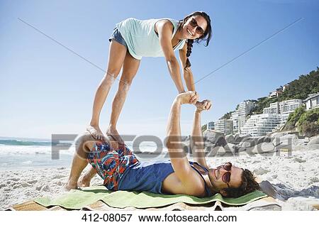 Stock Photo - Portrait of playful couple on beach. Fotosearch