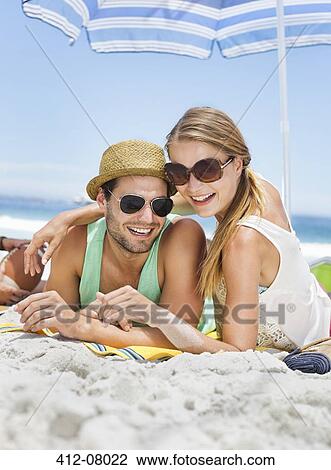 Portrait of smiling couple laying on beach View Large Photo Image Stock Image - Portrait of smiling couple laying on beach. Fotosearch