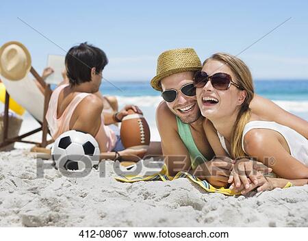 Portrait of smiling couple laying on beach View Large Photo Image Stock Photo - Portrait of smiling couple laying on beach. Fotosearch