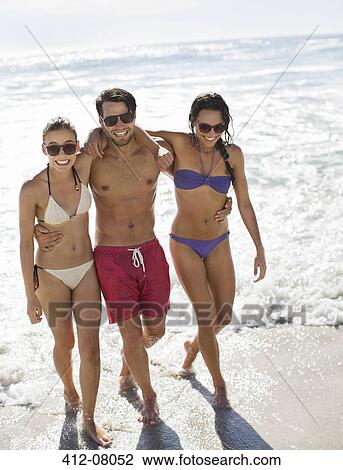 Portrait of smiling friends hugging on beach View Large Photo Image Stock Image - Portrait of smiling friends hugging on beach. Fotosearch