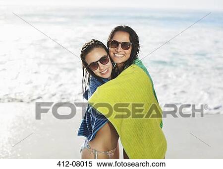 Portrait of smiling friends wrapped in towel on beach View Large Photo Image Stock Photography - Portrait of smiling friends wrapped in towel on beach. Fotosearch