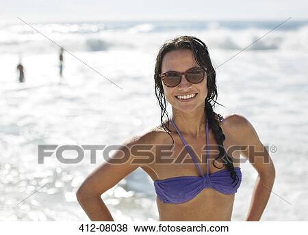 Portrait of smiling woman in bikini and sunglasses at beach View Large Photo Image Stock Photo - Portrait of smiling woman in bikini and sunglasses at beach. Fotosearch