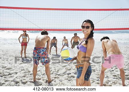 Portrait of smiling woman playing beach volleyball with friends View Large Photo Image Stock Image - Portrait of smiling woman playing beach volleyball with friends. Fotosearch