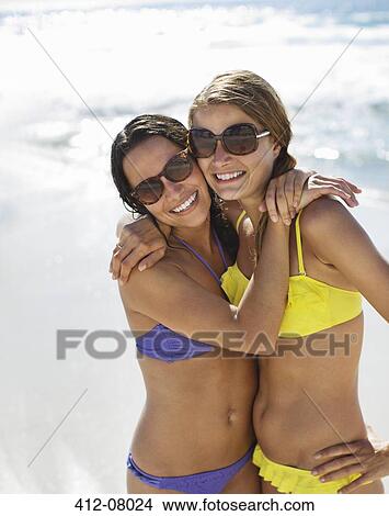 Portrait of smiling women in bikinis hugging on beach View Large Photo Image Picture - Portrait of smiling women in bikinis hugging on beach. Fotosearch