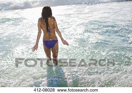 Woman in bikini wading in ocean View Large Photo Image Stock Photo - Woman in bikini wading in ocean. Fotosearch