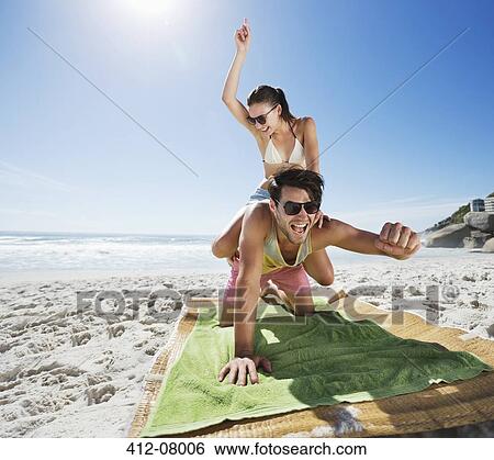Woman piggybacking enthusiastic man on beach View Large Photo Image Stock Photograph - Woman piggybacking enthusiastic man on beach. Fotosearch