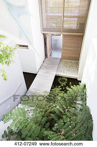 Stock Photo - Footbridge in courtyard of modern house. Fotosearch