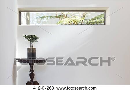 Stock Image - Long window above table in modern house. Fotosearch