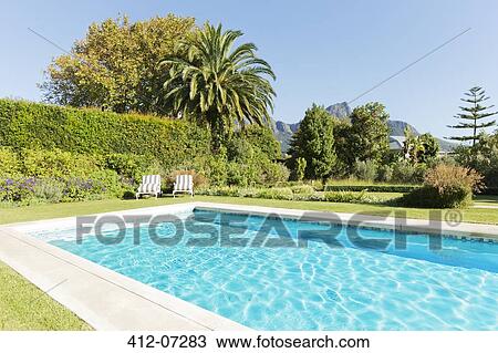 Stock Image - Luxury swimming pool and garden. Fotosearch
