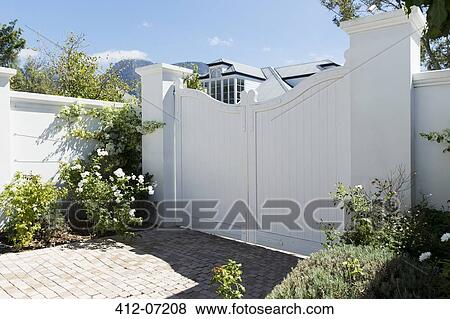 Stock Photo - White gate outside luxury house. Fotosearch