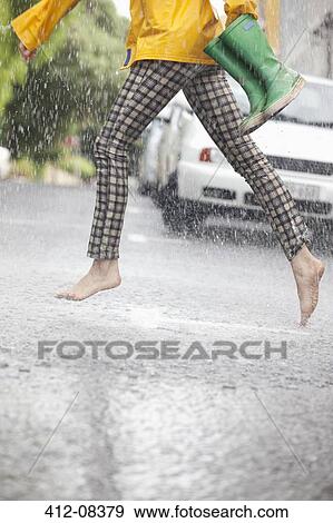Barefoot woman running across street in rain View Large Photo Image Stock Photo - Barefoot woman running across street in rain. Fotosearch