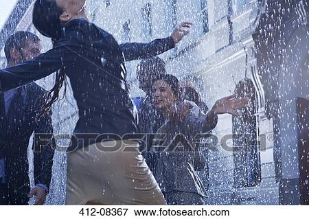 Business people dancing in rain View Large Photo Image Stock Photo - Business people dancing in rain. Fotosearch