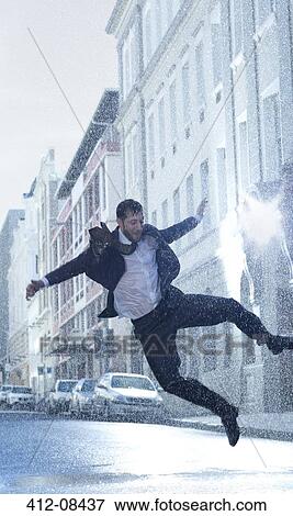 Businessman dancing in rainy street View Large Photo Image Stock Photo - Businessman dancing in rainy street. Fotosearch