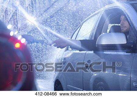 Businessman in car reaching for package in rain View Large Photo Image Stock Photograph - Businessman in car reaching for package in rain. Fotosearch