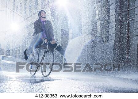 Businessman riding bicycle in rainy street View Large Photo Image Stock Image - Businessman riding bicycle in rainy street. Fotosearch