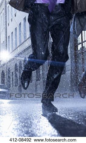 Businessman running in rainy street View Large Photo Image Stock Image - Businessman running in rainy street. Fotosearch