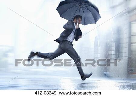 Businessman running with umbrella in rainy street View Large Photo Image Stock Photo - Businessman running with umbrella in rainy street. Fotosearch