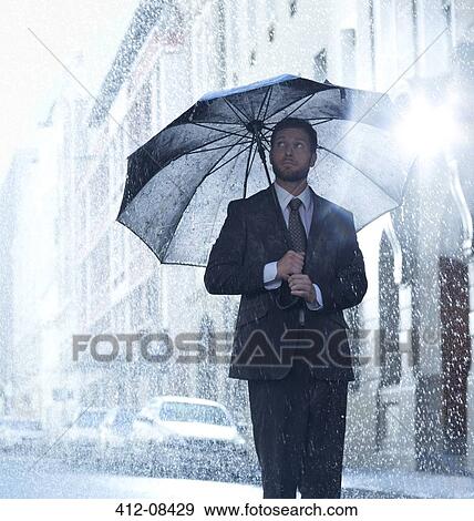 Businessman under umbrella in rainy street View Large Photo Image Stock Photo - Businessman under umbrella in rainy street. Fotosearch