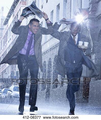 Businessmen carrying coffee and covering heads with newspaper in rain View Large Photo Image Stock Photo - Businessmen carrying coffee and covering heads with newspaper in rain. Fotosearch