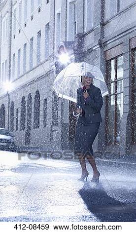 Businesswoman under umbrella in rainy street View Large Photo Image Stock Photo - Businesswoman under umbrella in rainy street. Fotosearch