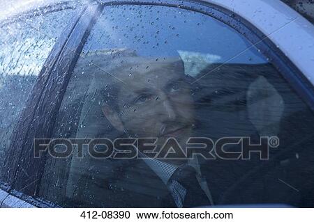 Close up of businessman in car looking up at rain View Large Photo Image Stock Image - Close up of businessman in car looking up at rain. Fotosearch