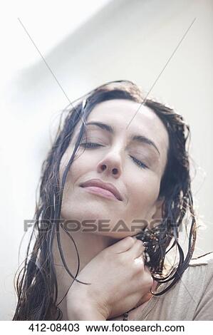 Stock Image - Close up portrait of serene woman with wet hair. Fotosearch