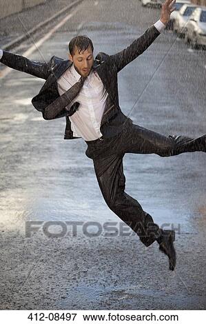 Enthusiastic businessman dancing in rainy street View Large Photo Image Stock Photo - Enthusiastic businessman dancing in rainy street. Fotosearch