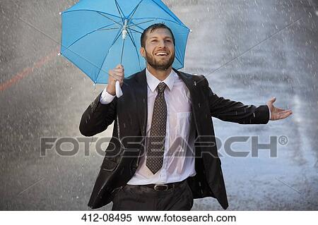 Enthusiastic businessman with tiny umbrella in rainy street View Large Photo Image Stock Photography - Enthusiastic businessman with tiny umbrella in rainy street. Fotosearch