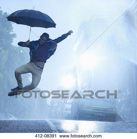 Enthusiastic man with umbrella jumping in rain View Large Photo Image Stock Image - Enthusiastic man with umbrella jumping in rain. Fotosearch