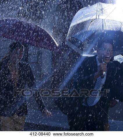 Happy business people running with umbrellas in rain View Large Photo Image Stock Image - Happy business people running with umbrellas in rain. Fotosearch