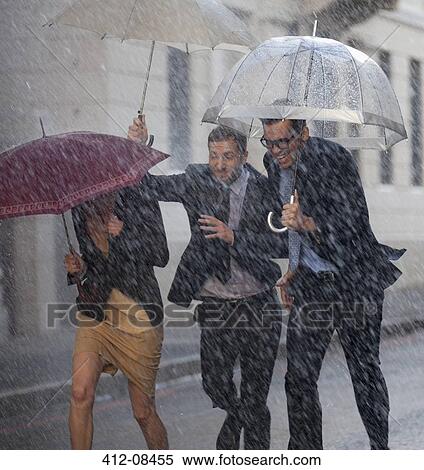Happy business people with umbrellas running in rainy street View Large Photo Image Stock Photography - Happy business people with umbrellas running in rainy street. Fotosearch