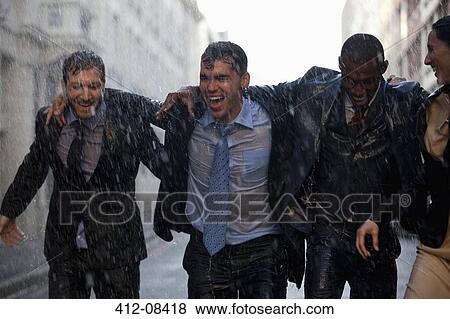 Happy businessmen walking in rainy street View Large Photo Image Stock Photo - Happy businessmen walking in rainy street. Fotosearch