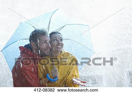 Happy couple under umbrella in rain View Large Photo Image Stock Image - Happy couple under umbrella in rain. Fotosearch