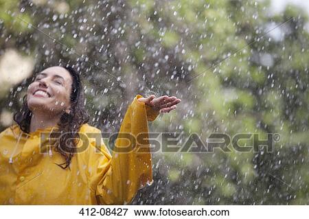 Happy woman standing with arms outstretched in rain View Large Photo Image Stock Photo - Happy woman standing with arms outstretched in rain. Fotosearch