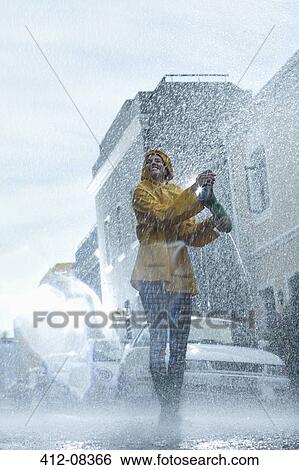 Stock Photograph - Happy woman walking barefoot in rain. Fotosearch