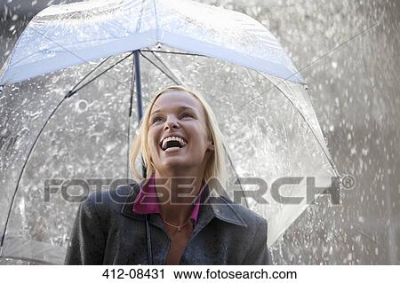 Laughing businesswoman under umbrella in rain View Large Photo Image Stock Image - Laughing businesswoman under umbrella in rain. Fotosearch
