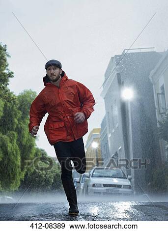 Man in raincoat running in rain View Large Photo Image Stock Photo - Man in raincoat running in rain. Fotosearch