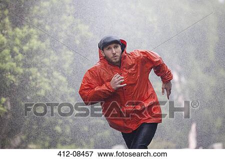 Man in raincoat running in rain View Large Photo Image Stock Photo - Man in raincoat running in rain. Fotosearch