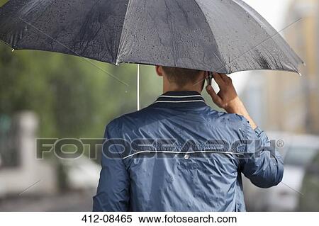 Man talking on cell phone under umbrella in rain View Large Photo Image Stock Photography - Man talking on cell phone under umbrella in rain. Fotosearch