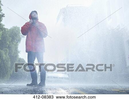 Man wearing raincoat in rainy street View Large Photo Image Stock Image - Man wearing raincoat in rainy street. Fotosearch