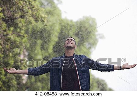 Man with arms outstretched in rain View Large Photo Image Stock Photo - Man with arms outstretched in rain. Fotosearch