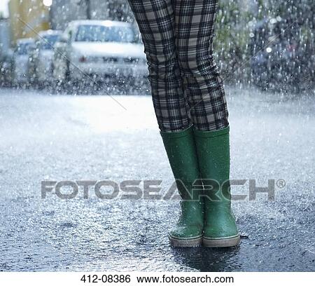 Rain falling around woman in wellingtons View Large Photo Image Stock Photograph - Rain falling around woman in wellingtons. Fotosearch