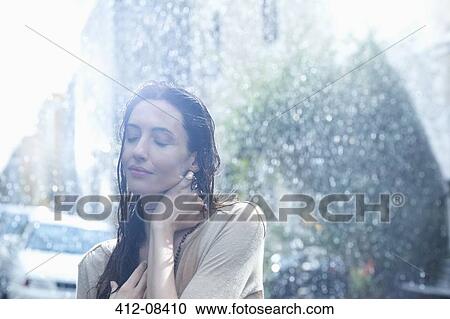 Serene woman standing in rain View Large Photo Image Stock Image - Serene woman standing in rain. Fotosearch