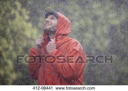 Smiling man with raincoat looking up at rain View Large Photo Image Stock Image - Smiling man with raincoat looking up at rain. Fotosearch